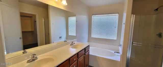 a bathroom with a tub sink and mirror