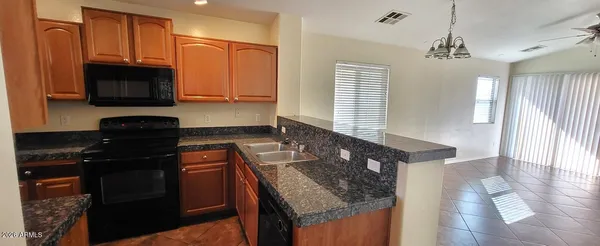 a kitchen with granite countertop stainless steel appliances and wooden cabinets