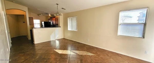 a view of a hallway with wooden floor and a living room