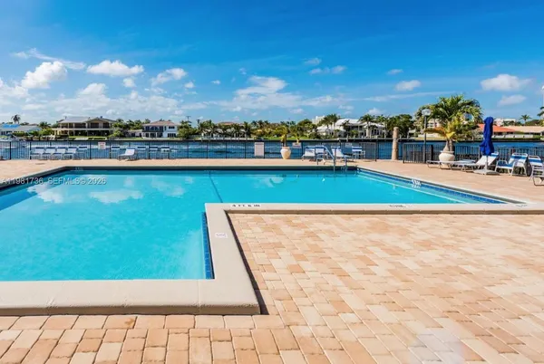 a view of swimming pool with outdoor seating and buildings in the background