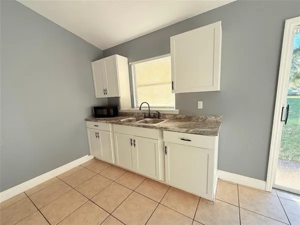 a kitchen with granite countertop a stove a sink and a refrigerator