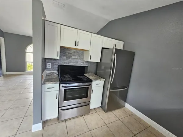 a kitchen with granite countertop a refrigerator and a stove