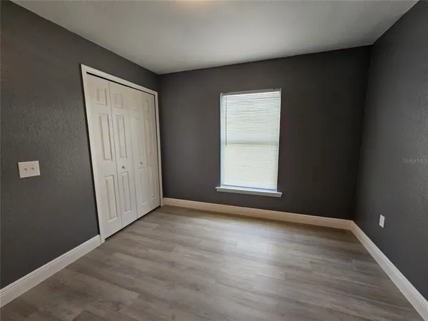 a view of an empty room with window and bathroom