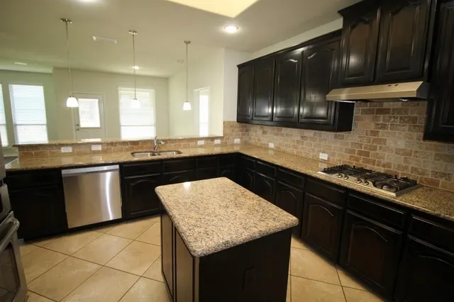 a kitchen with a sink and a stove top oven