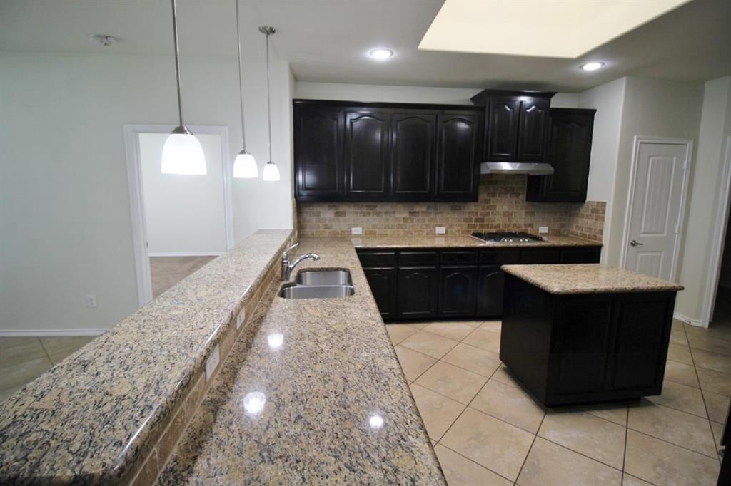 1205 Crest Ridge Drive Glenn Heights, TX 75154 - Photo 8 of 27 a large hall with kitchen island granite countertop a sink a counter top space and cabinets