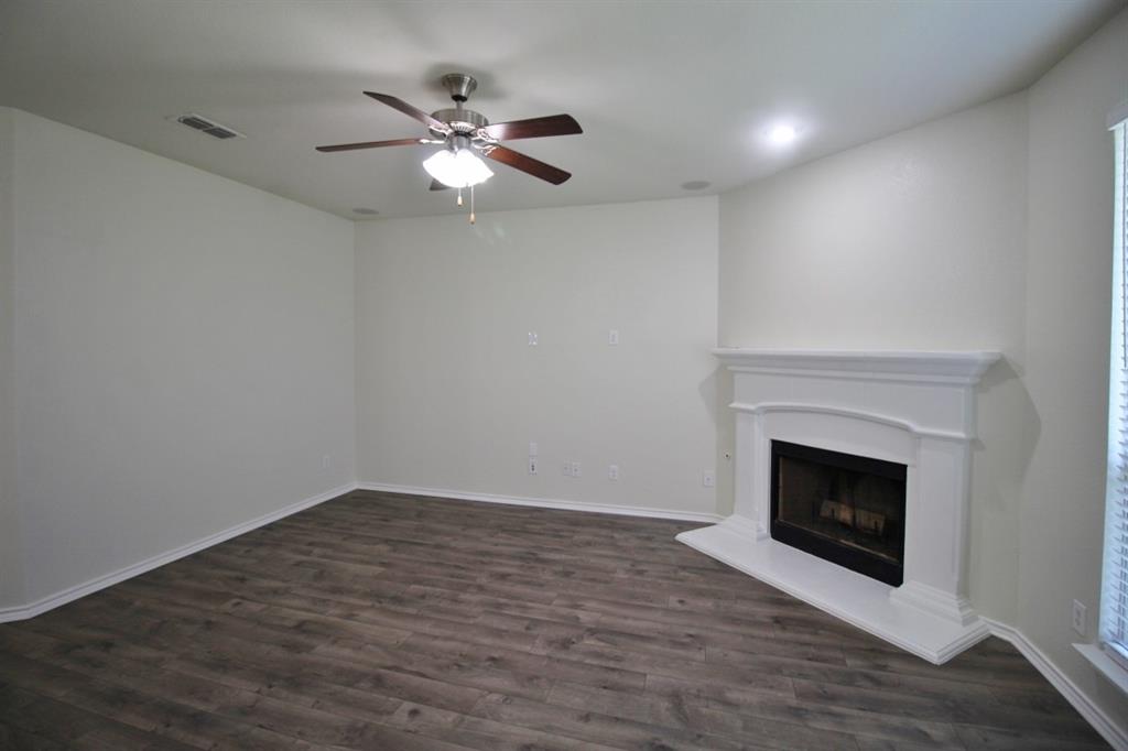 1205 Crest Ridge Drive Glenn Heights, TX 75154 - Photo 10 of 27 a view of an empty room with wooden floor and fireplace
