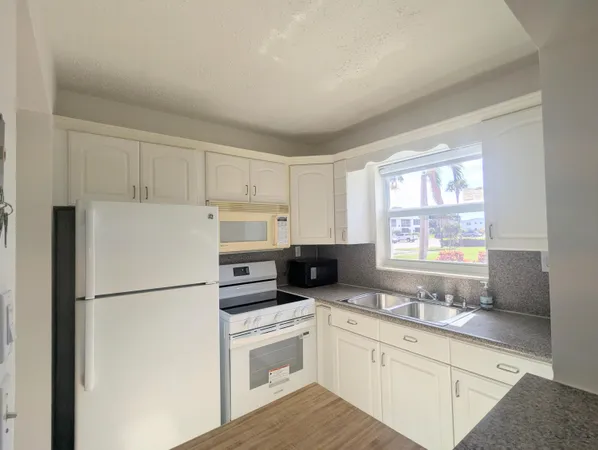 a kitchen with refrigerator a sink and a window