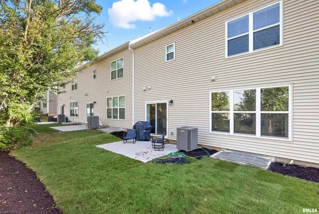 a backyard of a house with table and chairs