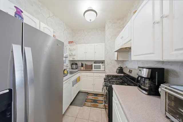 a kitchen with stainless steel appliances a refrigerator sink and cabinets