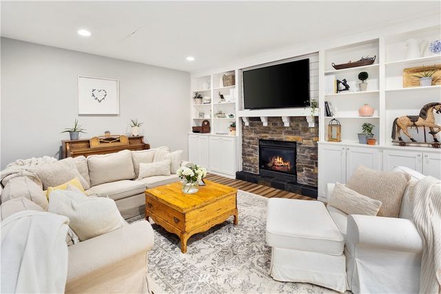 a living room with furniture a fireplace and a flat screen tv