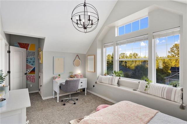 a living room with furniture a chandelier and a large window