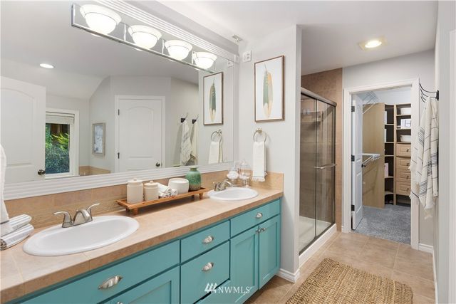 a spacious bathroom with double vanity and a mirror