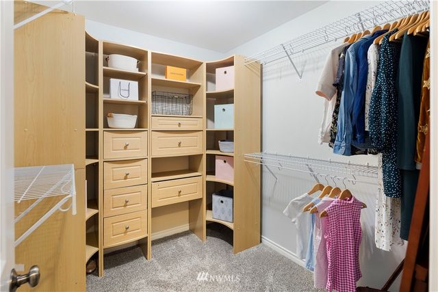 a view of walk in closet with clothes and shoes