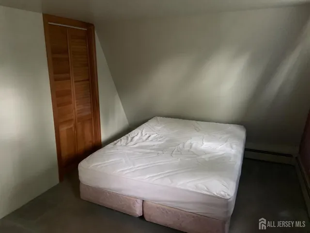 a bed sitting in a bedroom next to a wooden cabinet