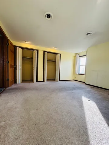 a view of an empty room with a fireplace and a window