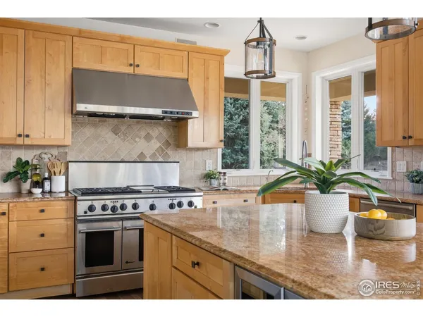 a kitchen with stainless steel appliances granite countertop a sink window and cabinets