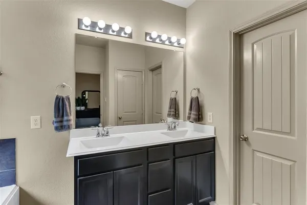 a bathroom with a double vanity sink and a mirror