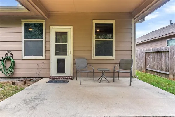 a backyard of a house with table and chairs