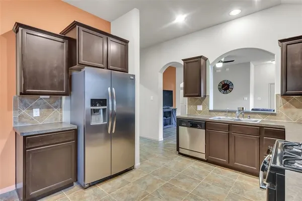 a modern kitchen with stainless steel appliances granite countertop a refrigerator and a stove