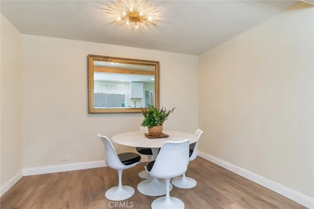 a dining room with furniture potted plants and wooden floor