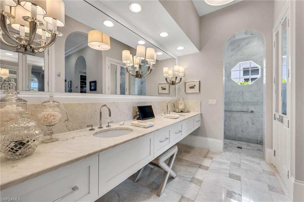 2157 Asti Court Naples, FL 34105 - Photo 16 of 29 Marble counters, floors with mosaic inserts, and mirrored His & Hers storage closets.