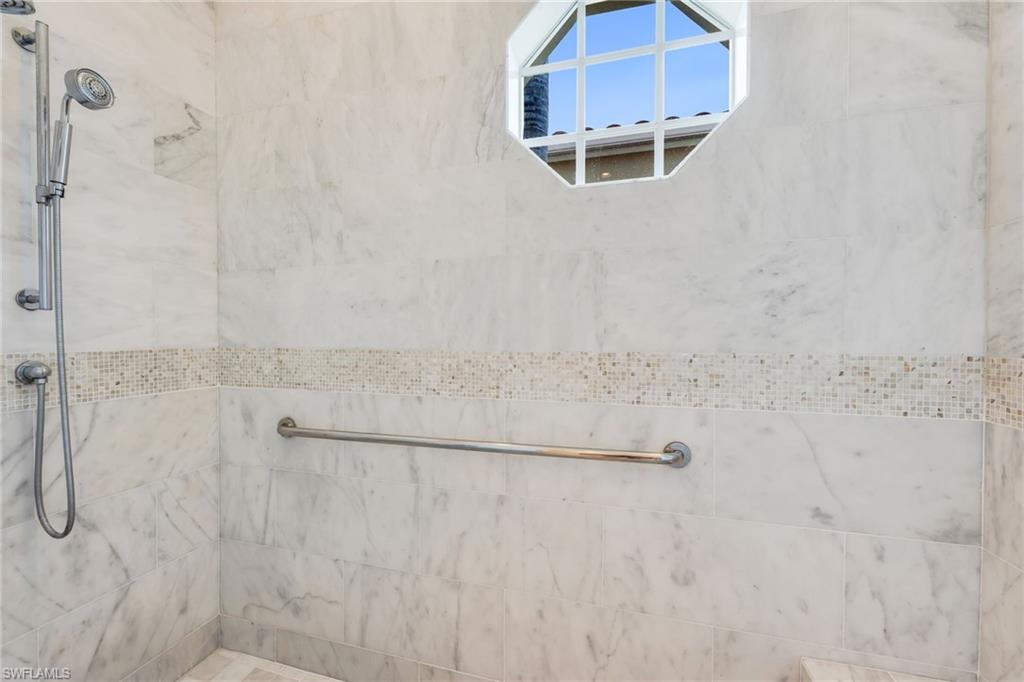 2157 Asti Court Naples, FL 34105 - Photo 17 of 29 The large shower has marble walls to the ceiling, with complementing mosaic inlays.