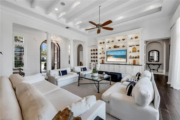 a living room with furniture ceiling fan and a window