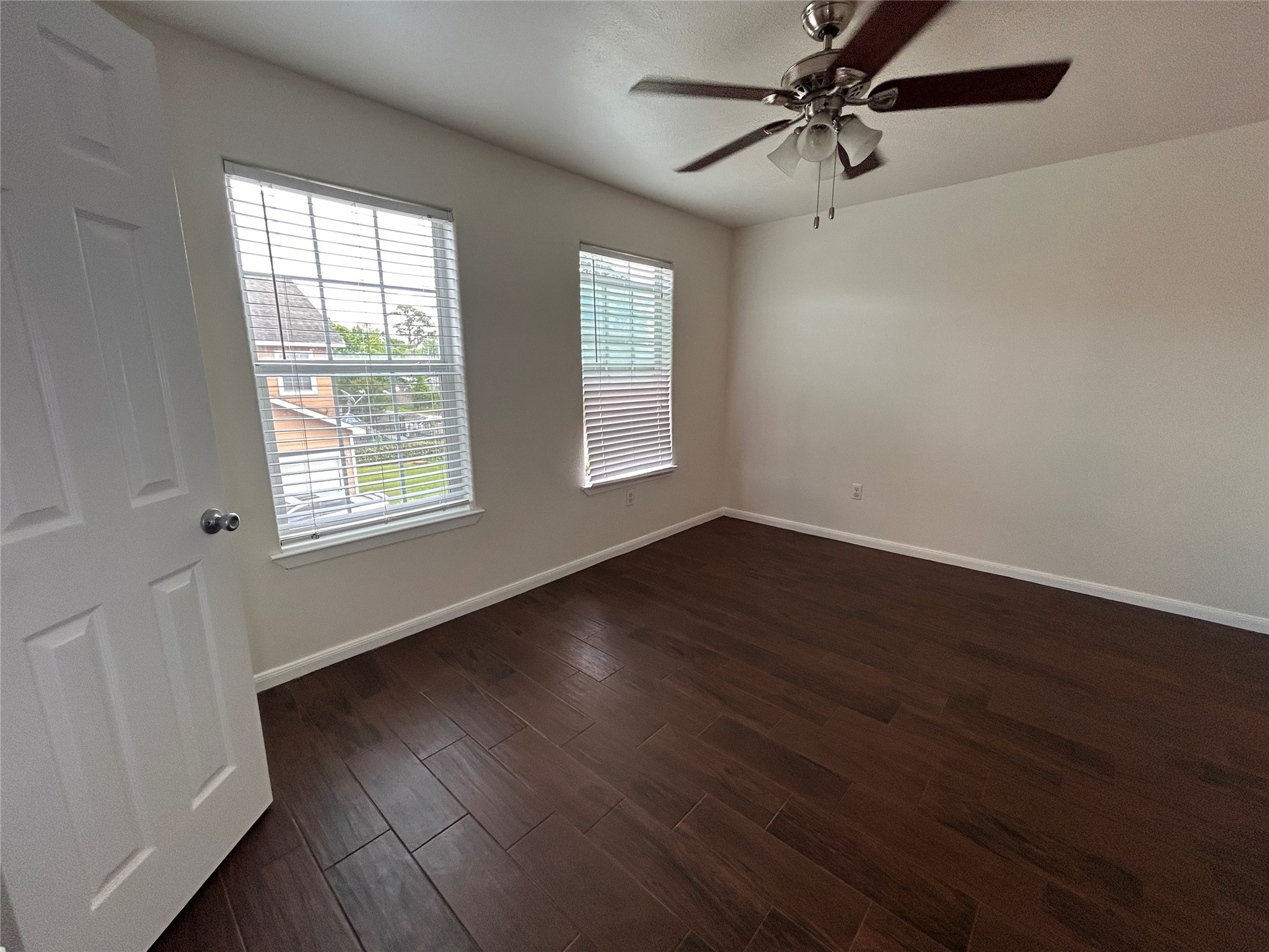 6837 Larkstone Street, Unit A Houston, TX 77028 - Photo 14 of 18 an empty room with wooden floor fan and windows