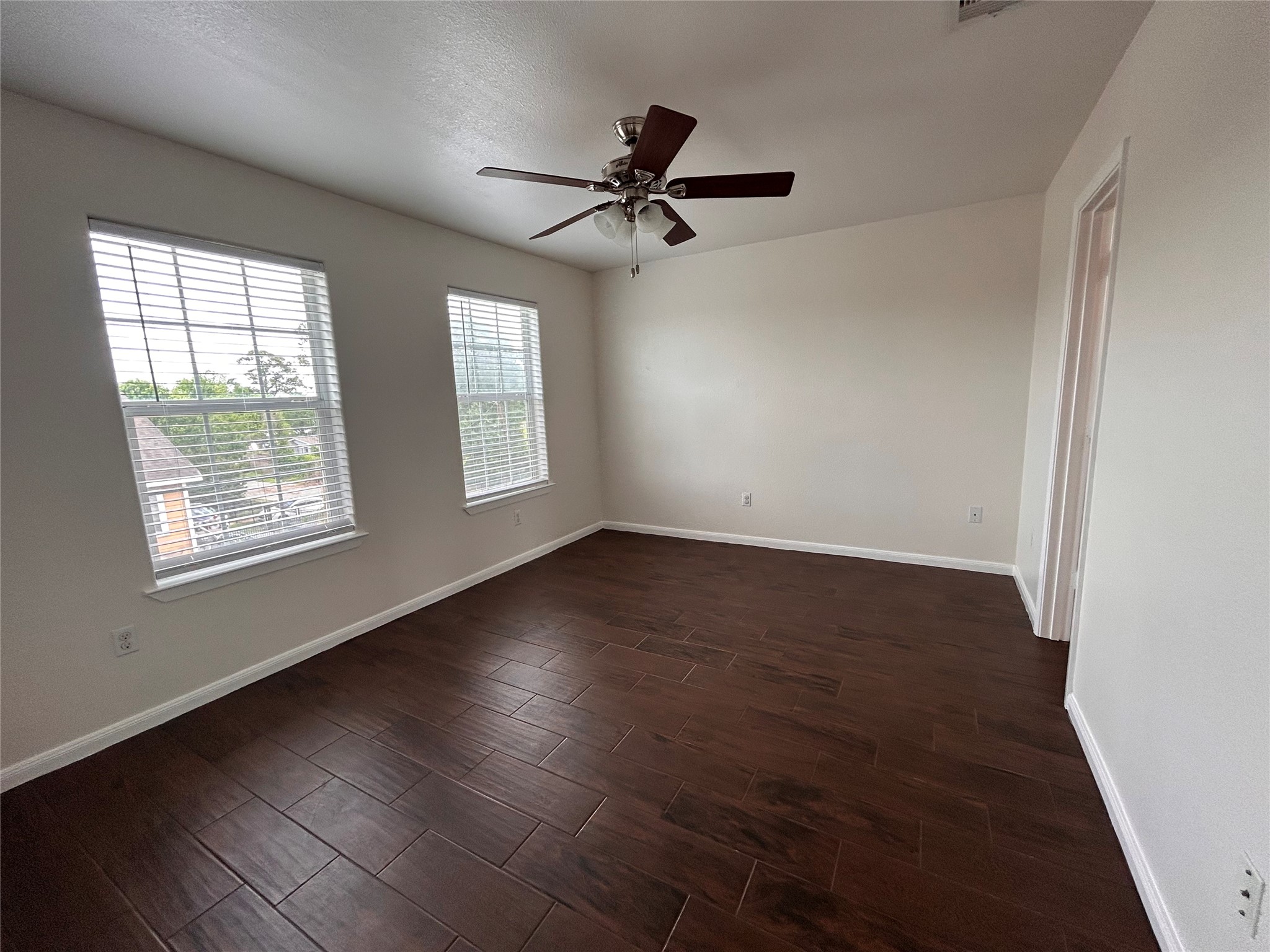 6837 Larkstone Street, Unit A Houston, TX 77028 - Photo 10 of 18 an empty room with wooden floor fan and windows