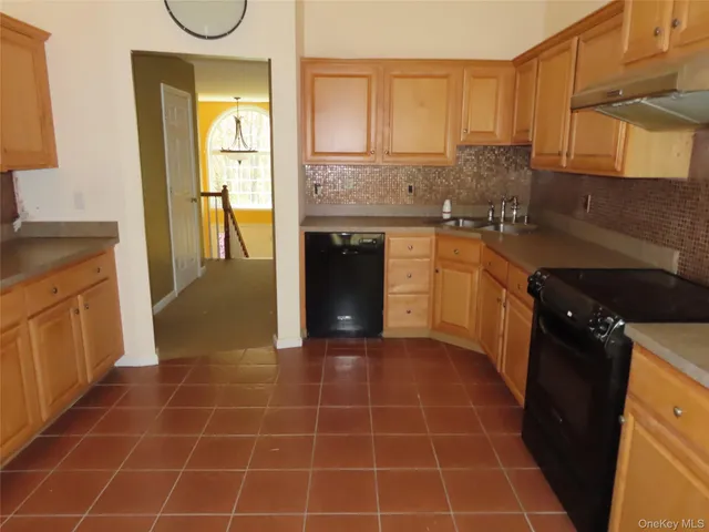 a kitchen with granite countertop a stove a sink and a refrigerator