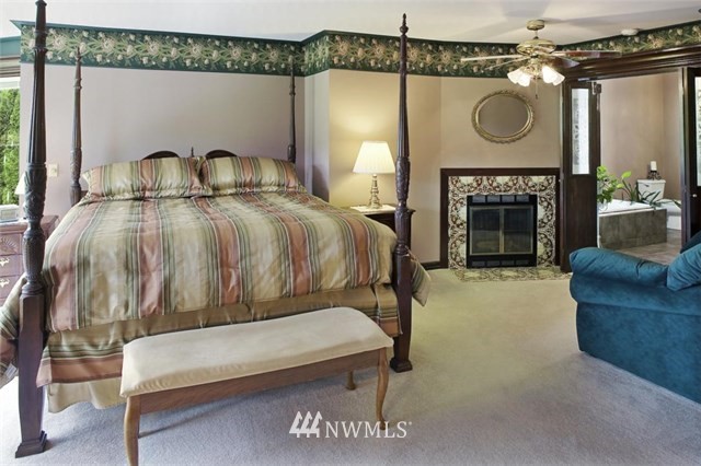 4566 Anderson Way Bellingham, WA 98226 - Photo 15 of 29 a bedroom with a bed a mirror and a fireplace