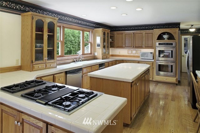 4566 Anderson Way Bellingham, WA 98226 - Photo 26 of 29 a kitchen with a stove a sink and a refrigerator