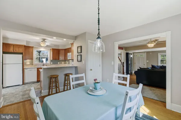 a view of a dining room and livingroom with furniture wooden floor a chandelier