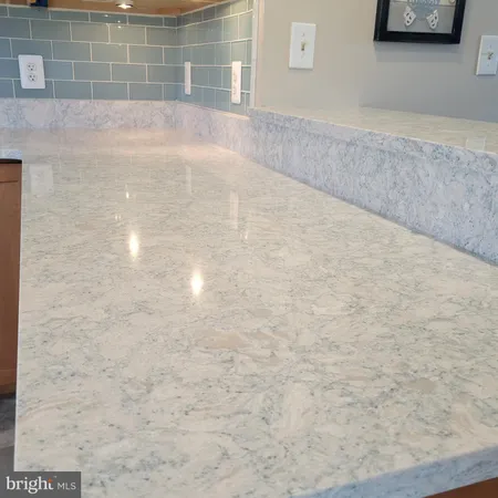 a kitchen with granite countertop white cabinets and white appliances