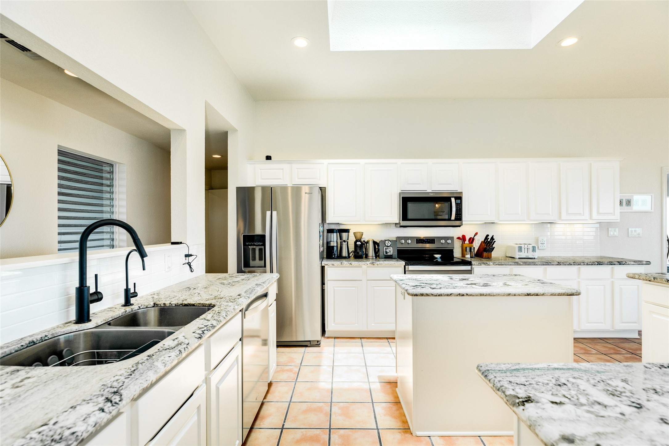 23331 Termini-San Luis Pass Road Galveston, TX 77554 - Photo 10 of 28 a kitchen with stainless steel appliances granite countertop a sink dishwasher a refrigerator and a stove with wooden floor