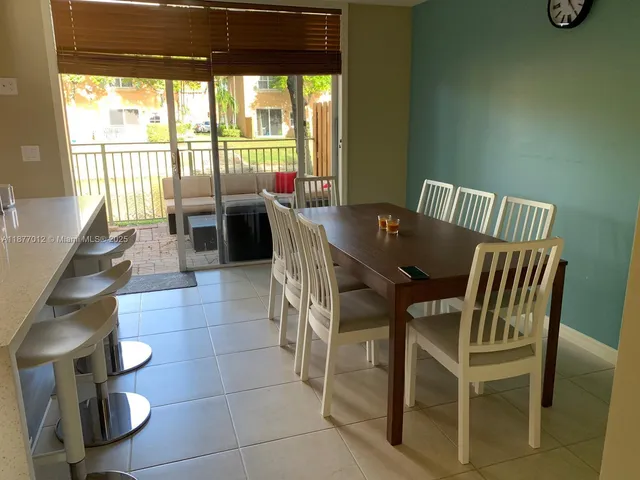 a open kitchen with stainless steel appliances granite countertop a stove a refrigerator a dining table and chairs with wooden floor