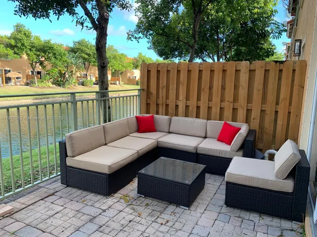 a view of a porch with furniture and wooden fence