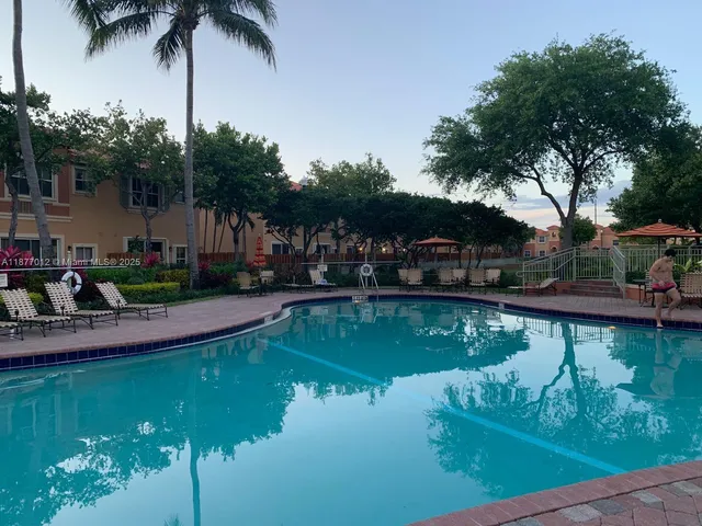 a view of a lake with a yard and large trees