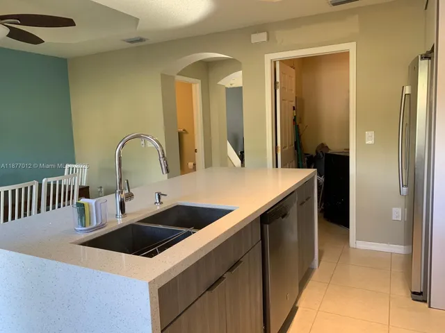 a kitchen with kitchen island a sink counter space and stainless steel appliances