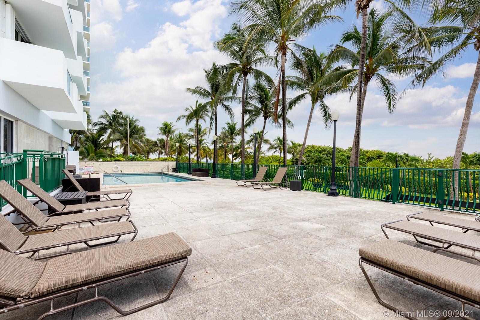 9195 Collins Avenue, Unit 710 Surfside, FL 33154 - Photo 7 of 15 a view of a backyard with couches under an umbrella