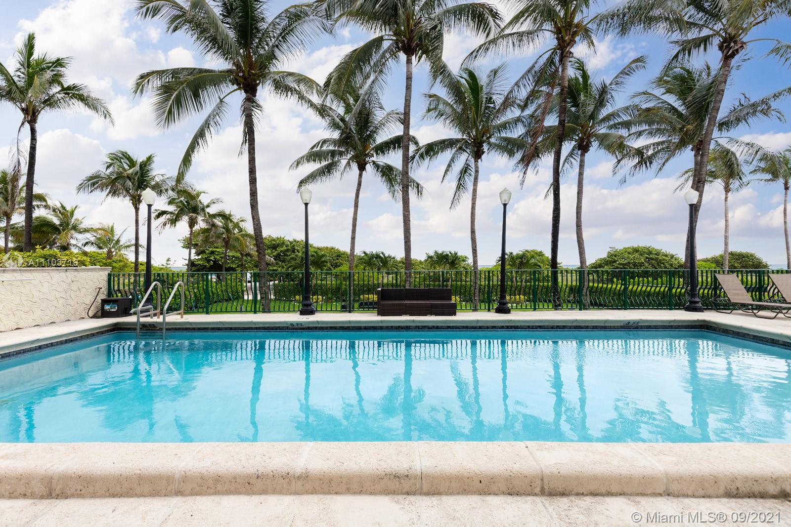 9195 Collins Avenue, Unit 710 Surfside, FL 33154 - Photo 8 of 15 a view of swimming pool with a yard and palm trees