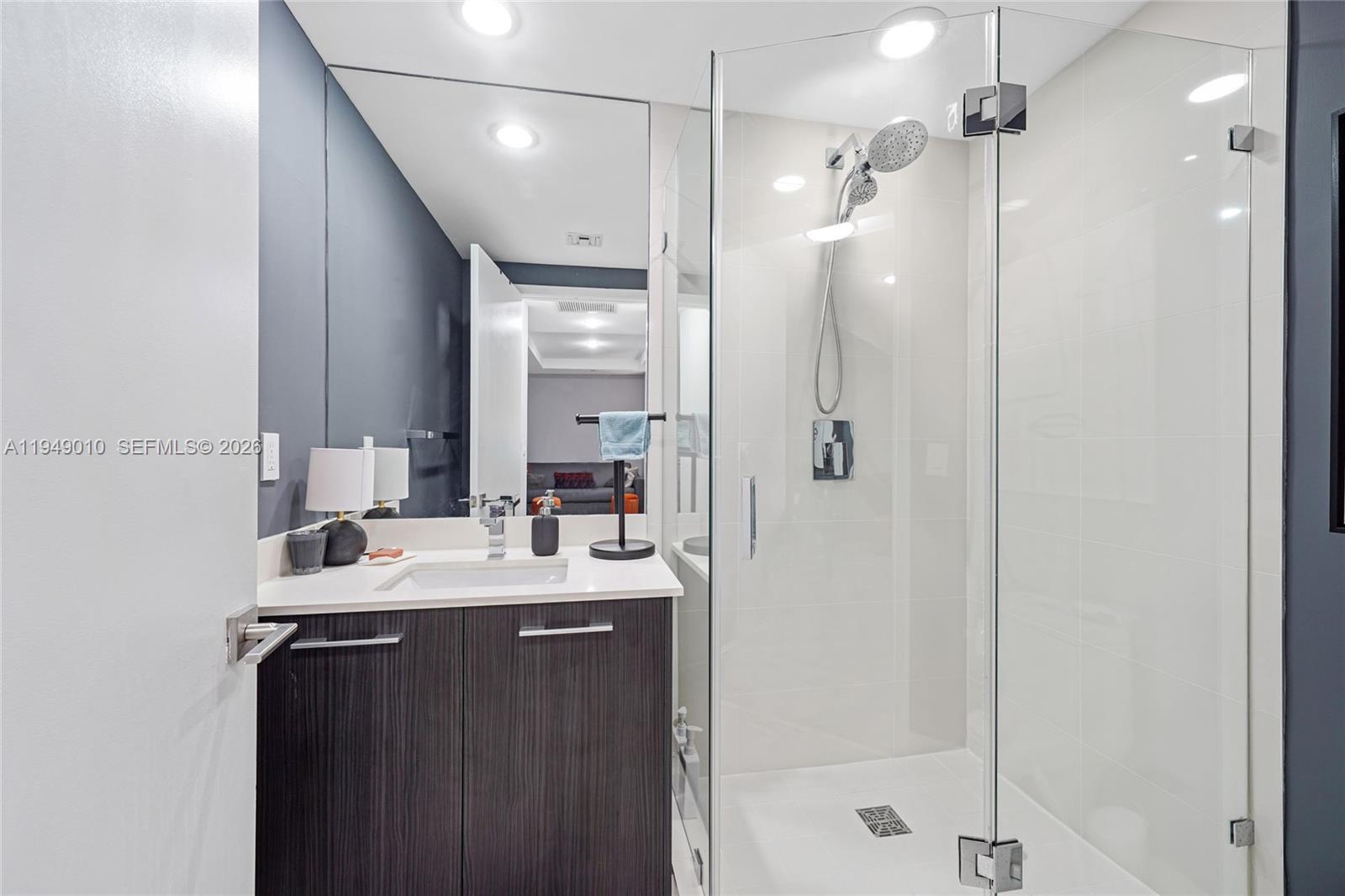 45 Southwest 9th Street, Unit 3405 Miami, FL 33130 - Photo 21 of 47 a bathroom with a double vanity sink mirror and shower