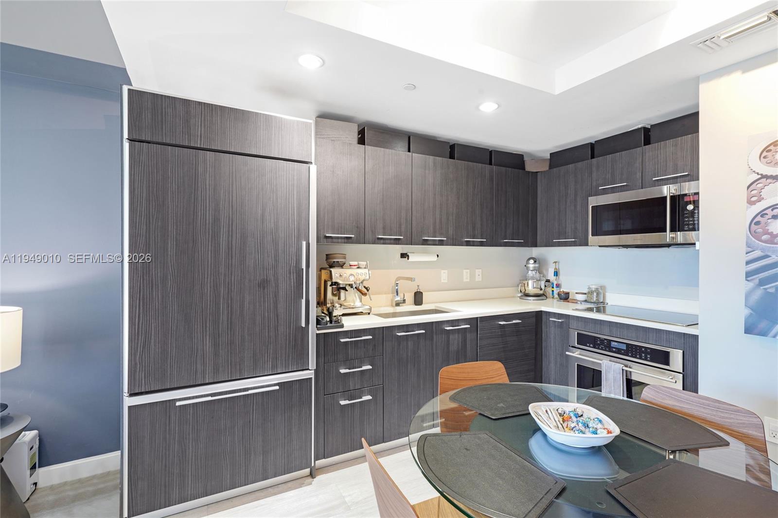 45 Southwest 9th Street, Unit 3405 Miami, FL 33130 - Photo 4 of 47 a kitchen with granite countertop stainless steel appliances a sink and a refrigerator