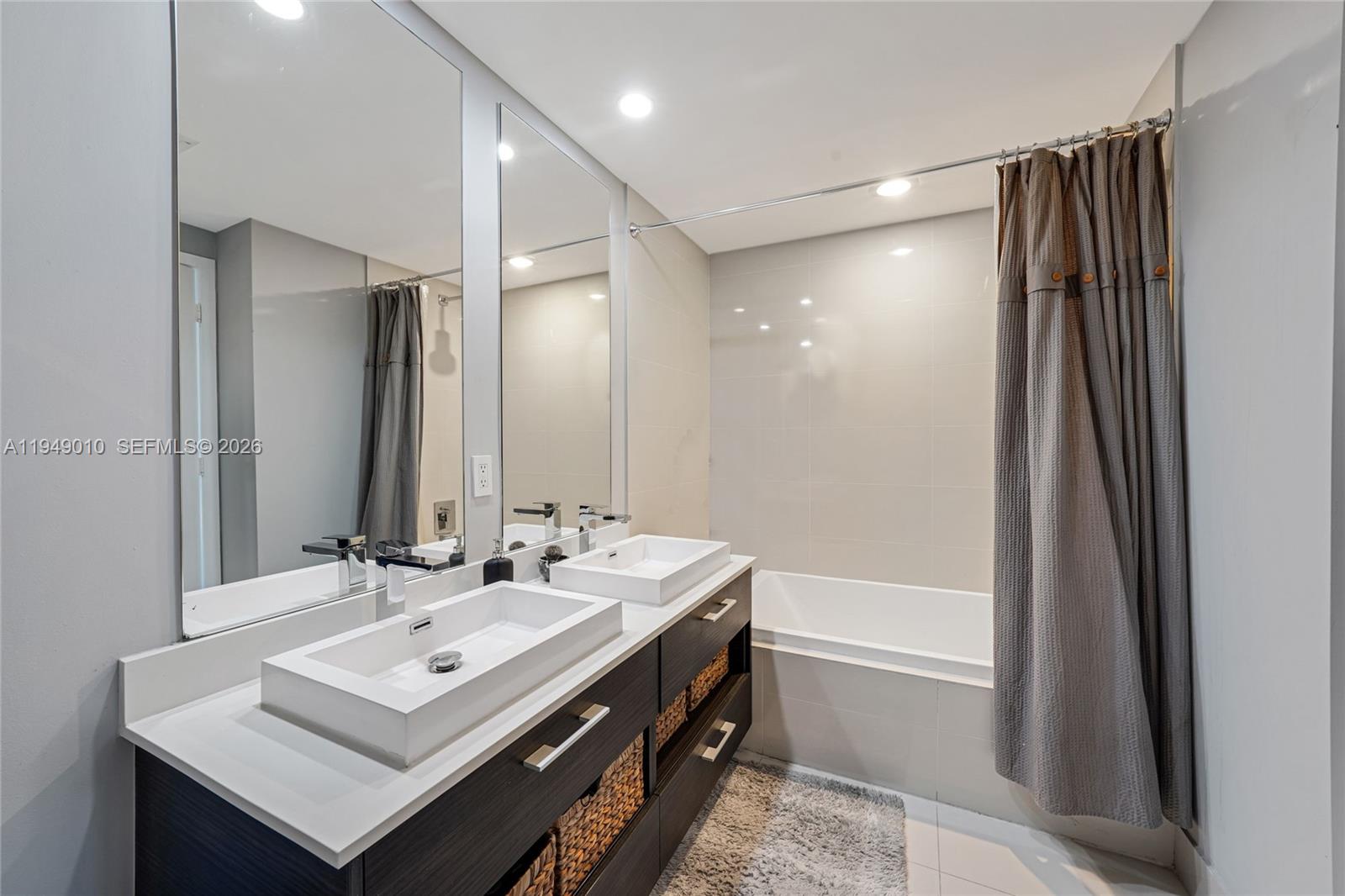 45 Southwest 9th Street, Unit 3405 Miami, FL 33130 - Photo 9 of 47 a bathroom with a sink double vanity mirror and a bathtub