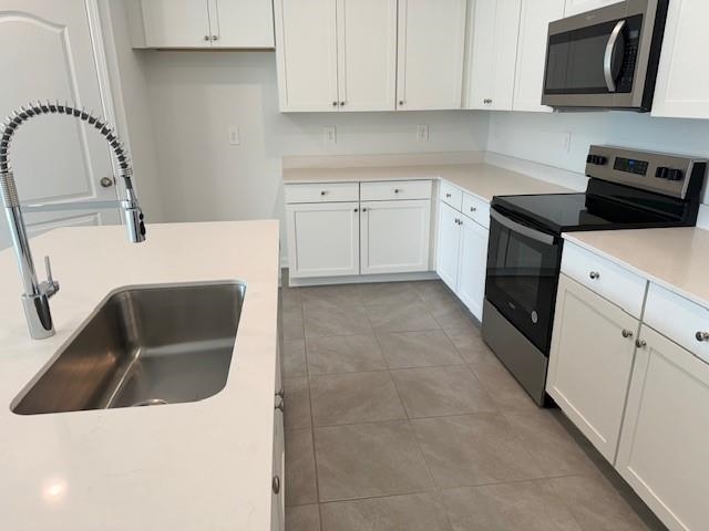 282 Redbud Road Palm Coast, FL 32137 - Photo 7 of 41 a kitchen with stainless steel appliances granite countertop a sink and a stove