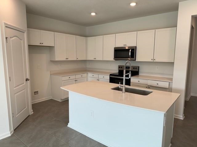 282 Redbud Road Palm Coast, FL 32137 - Photo 8 of 41 a kitchen with sink a microwave and cabinets