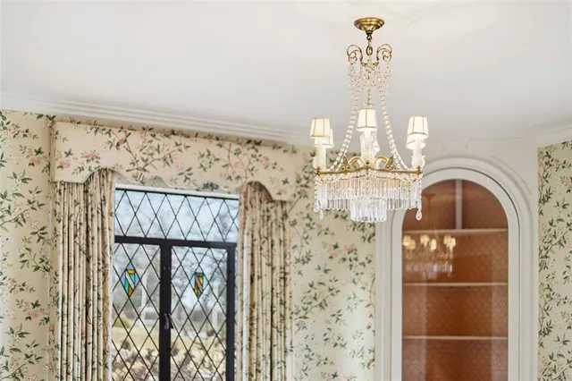 a view of an empty room with kitchen and a window