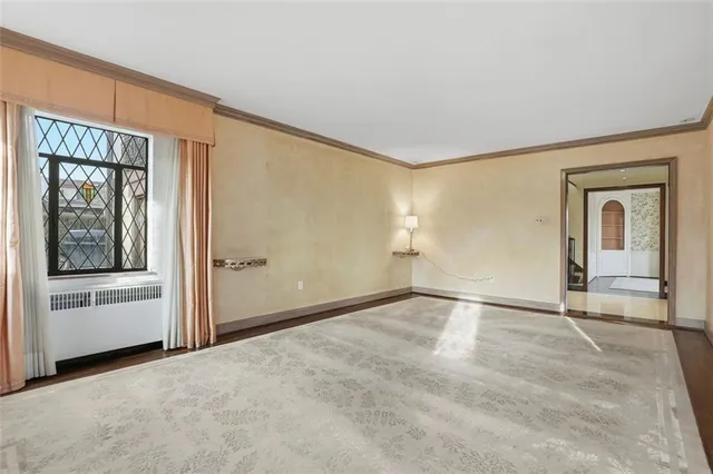 a view of an empty room with window and closet area