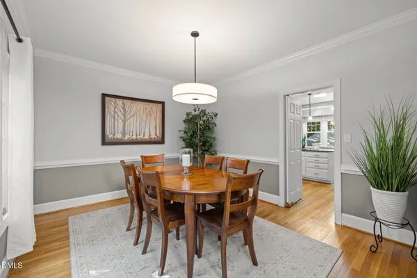 a dining room with furniture potted plants and wooden floor