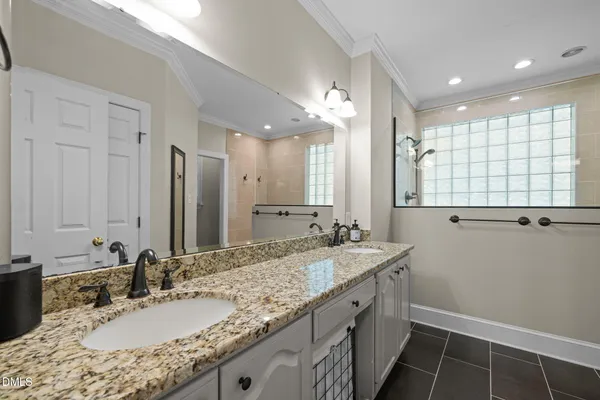 a bathroom with a granite countertop shower sink and mirror